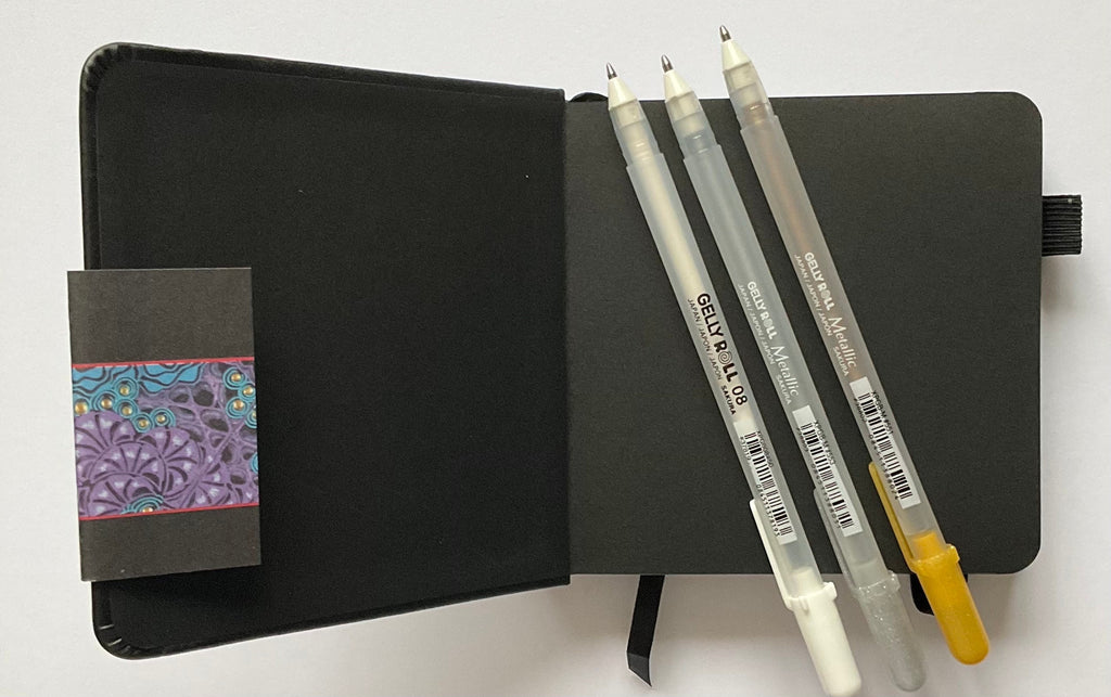Sakura square black page sketchbook with x3 08 mixed Gelly roll pens. Gold, Silver & white