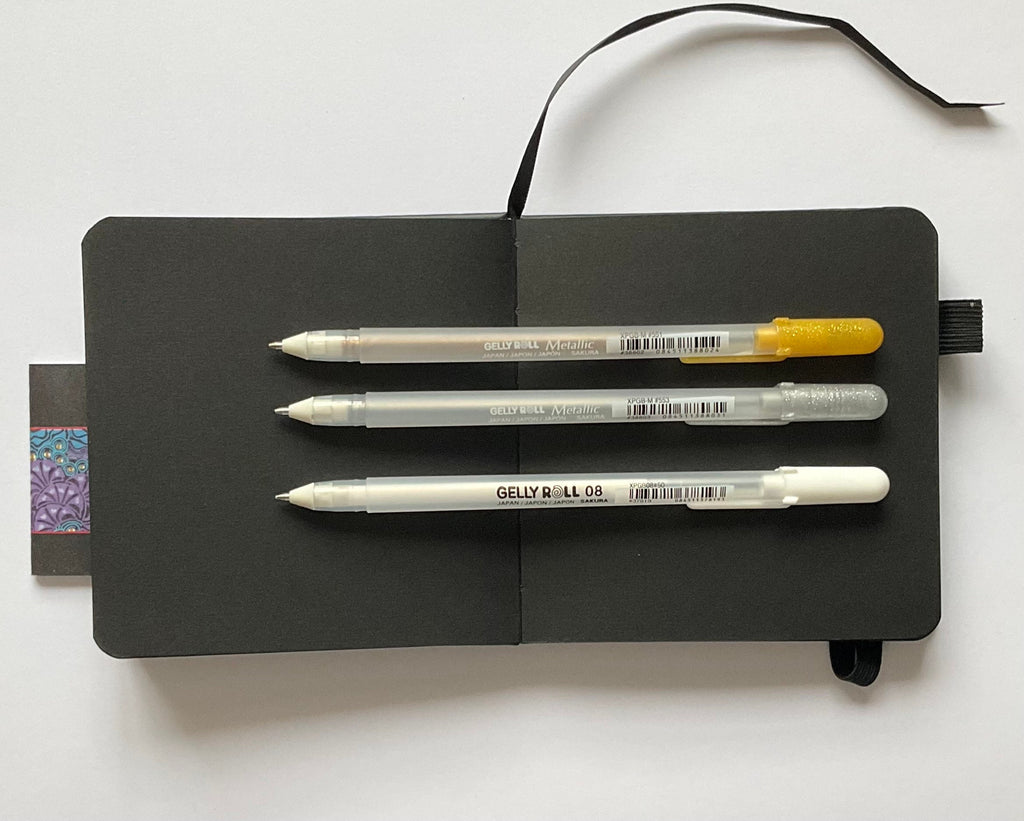 Sakura square black page sketchbook with x3 08 mixed Gelly roll pens. Gold, Silver & white